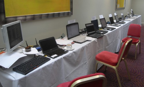 Table with server, router and laptops with exercise cards stuck on top